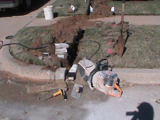 Installing French Drain and Curb Outlet  in Drainage System in Norman.